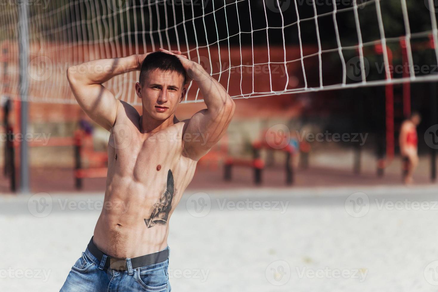 muscular male model with perfect body posing in blue jeans photo