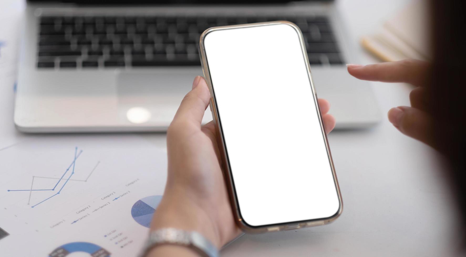 Cropped shot view of woman hands holding smart phone with blank copy space screen for your text message or information content, female reading text message on cell telephone during in office. photo