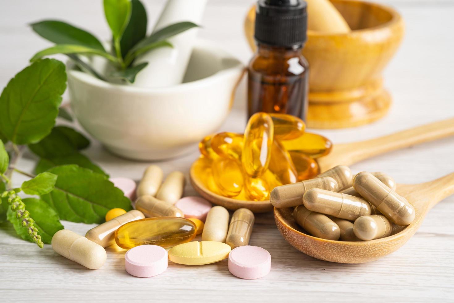 medicina alternativa cápsula orgánica a base de hierbas con vitamina e omega 3 aceite de pescado, mineral, medicamento con hojas de hierbas suplementos naturales para una vida sana y buena. foto