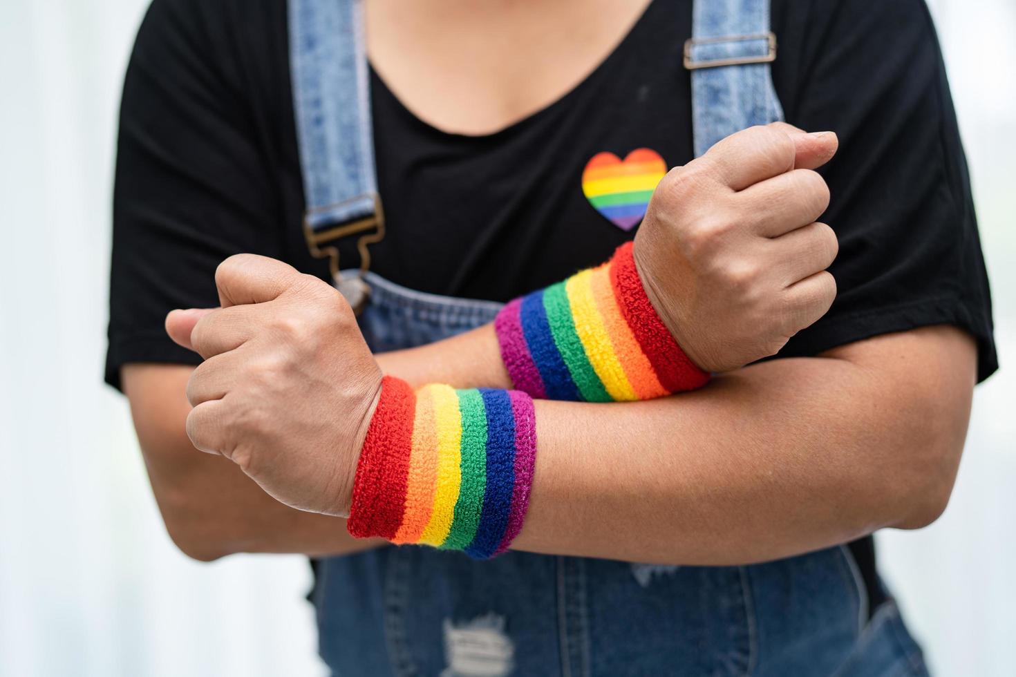 dama asiática con pulseras de la bandera del arco iris, símbolo del mes del orgullo lgbt celebran anualmente en junio las redes sociales de gays, lesbianas, bisexuales, transgénero, derechos humanos. foto