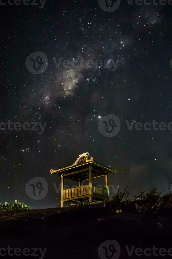 la galaxia de la vía láctea se eleva sobre la madera de la casa foto