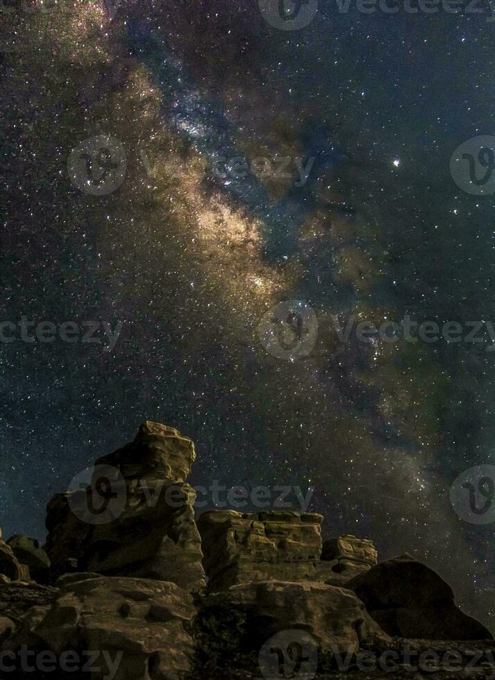 impresionante galaxia de la vía láctea se eleva por encima de las rocas en la noche foto