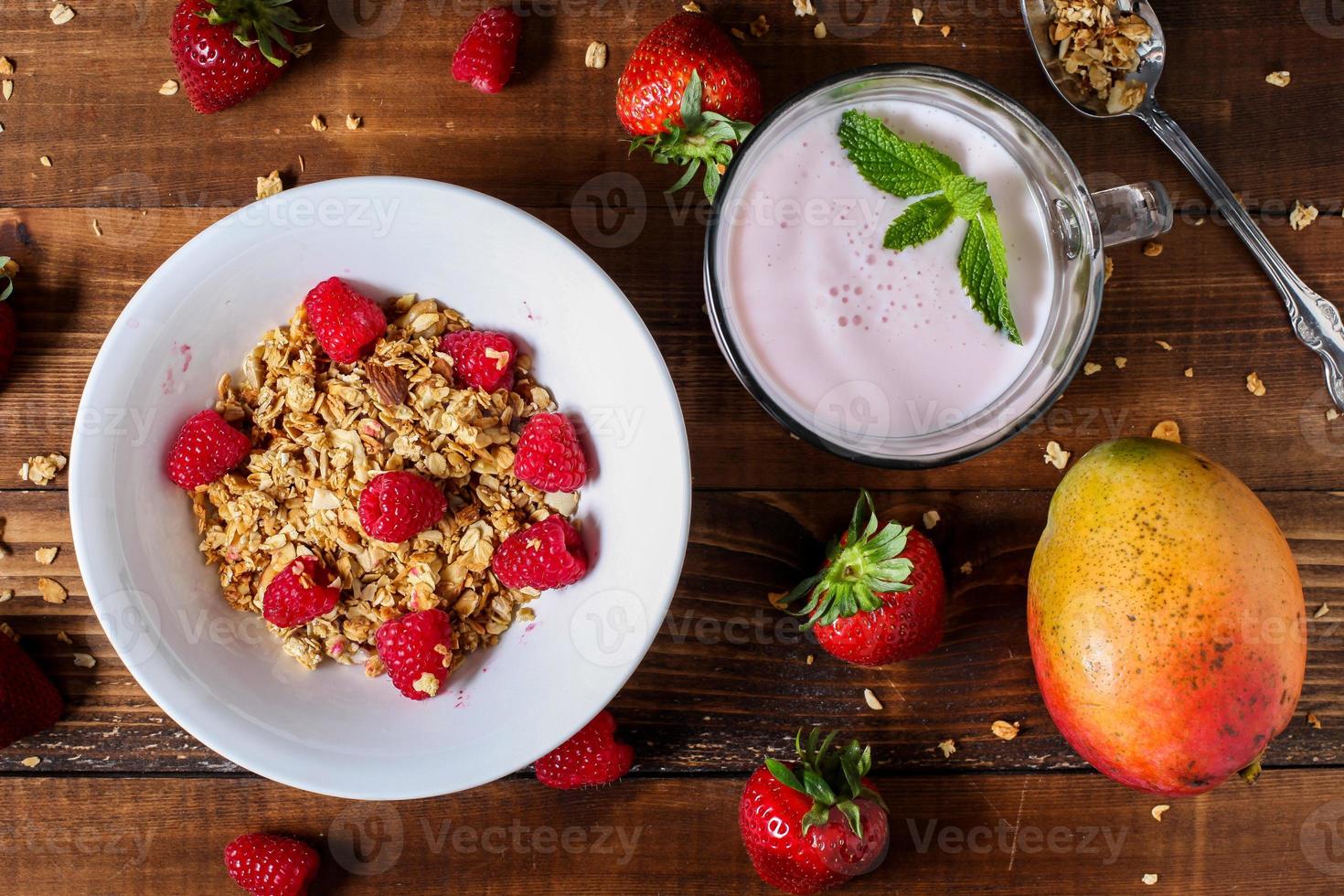 Strawberry smoothie with granola berries and mango table top view photo