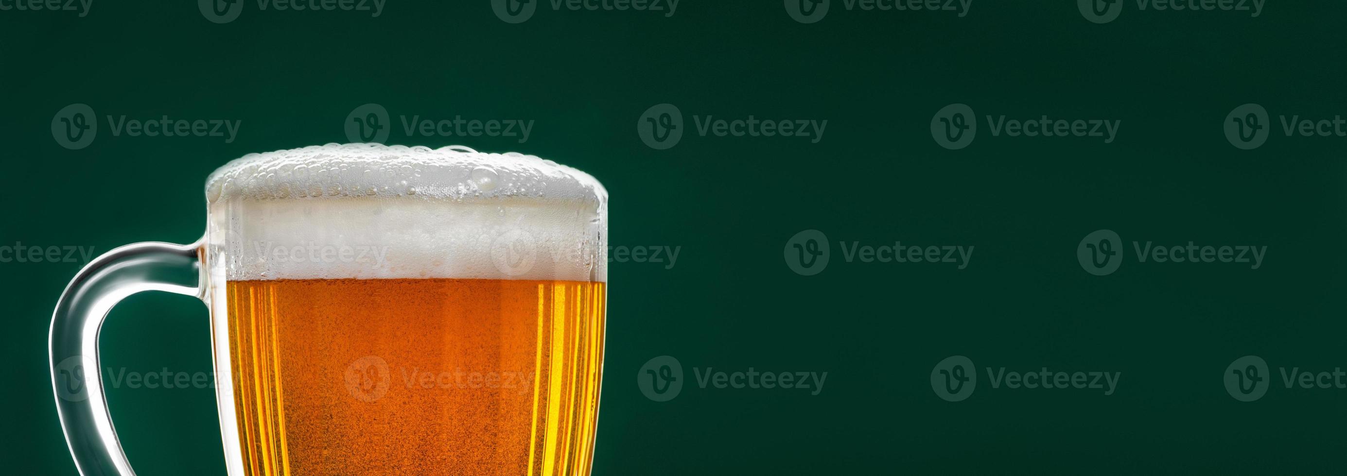 Mug with traditional Irish pale ale on a dark green background. photo