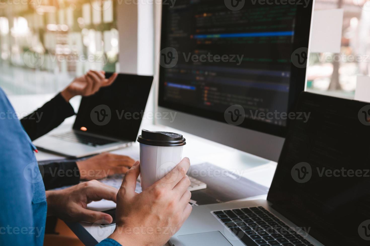 trabajando en la mañana con hombres de negocios están tomando café que trabaja con desarrolladores de software para analizar juntos el código escrito en el programa en la computadora. foto