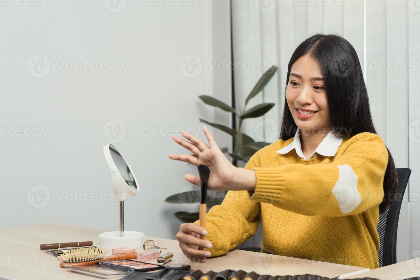 Young Asian beauty blogger is showcasing cosmetic products as well as tutorials on how to apply and record makeup tutorials on social media networks. photo