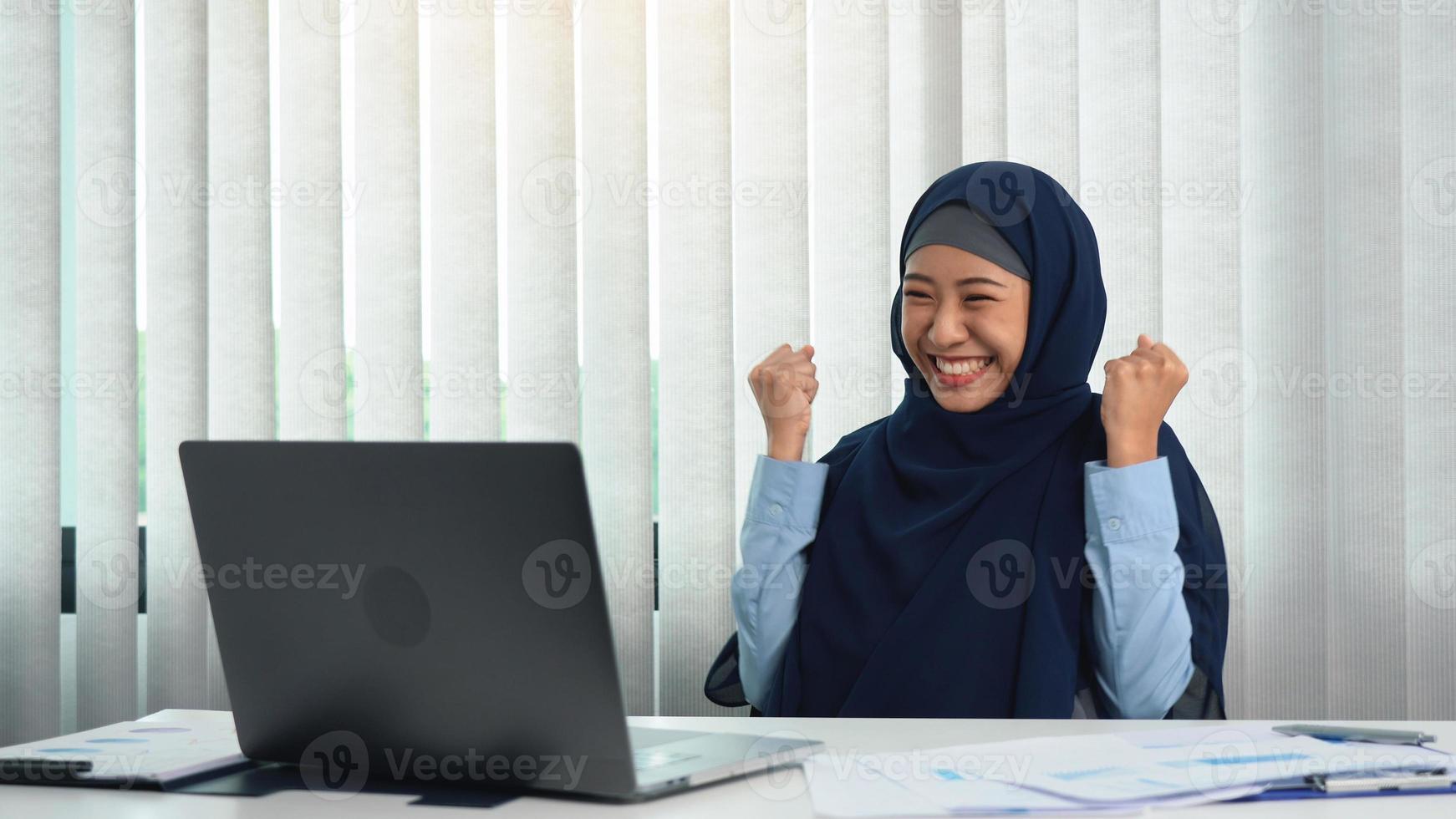 la mujer musulmana está haciendo una expresión feliz al completar sus objetivos. foto