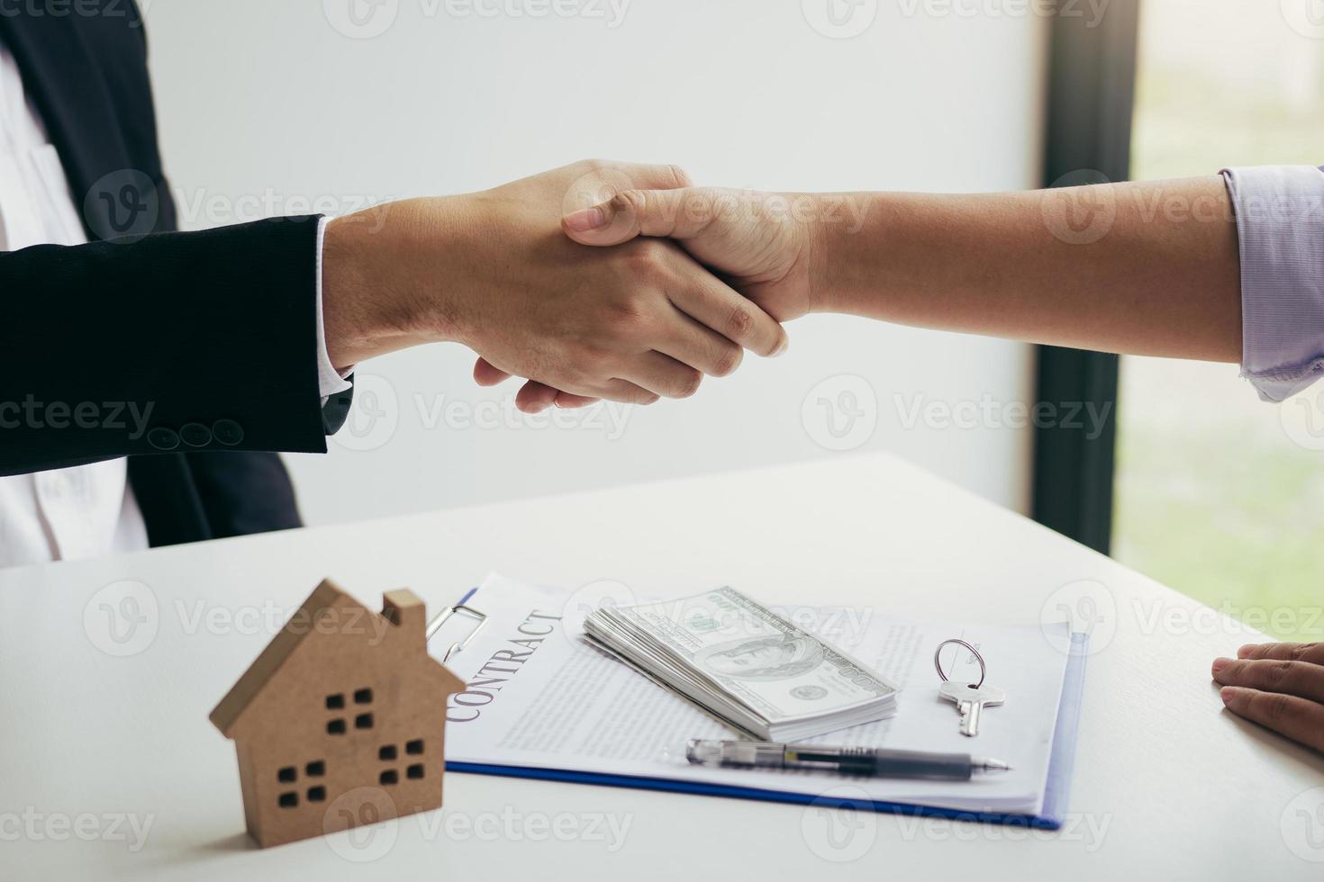 los agentes de ventas y compradores de casas trabajan para firmar nuevas casas y darse la mano. foto