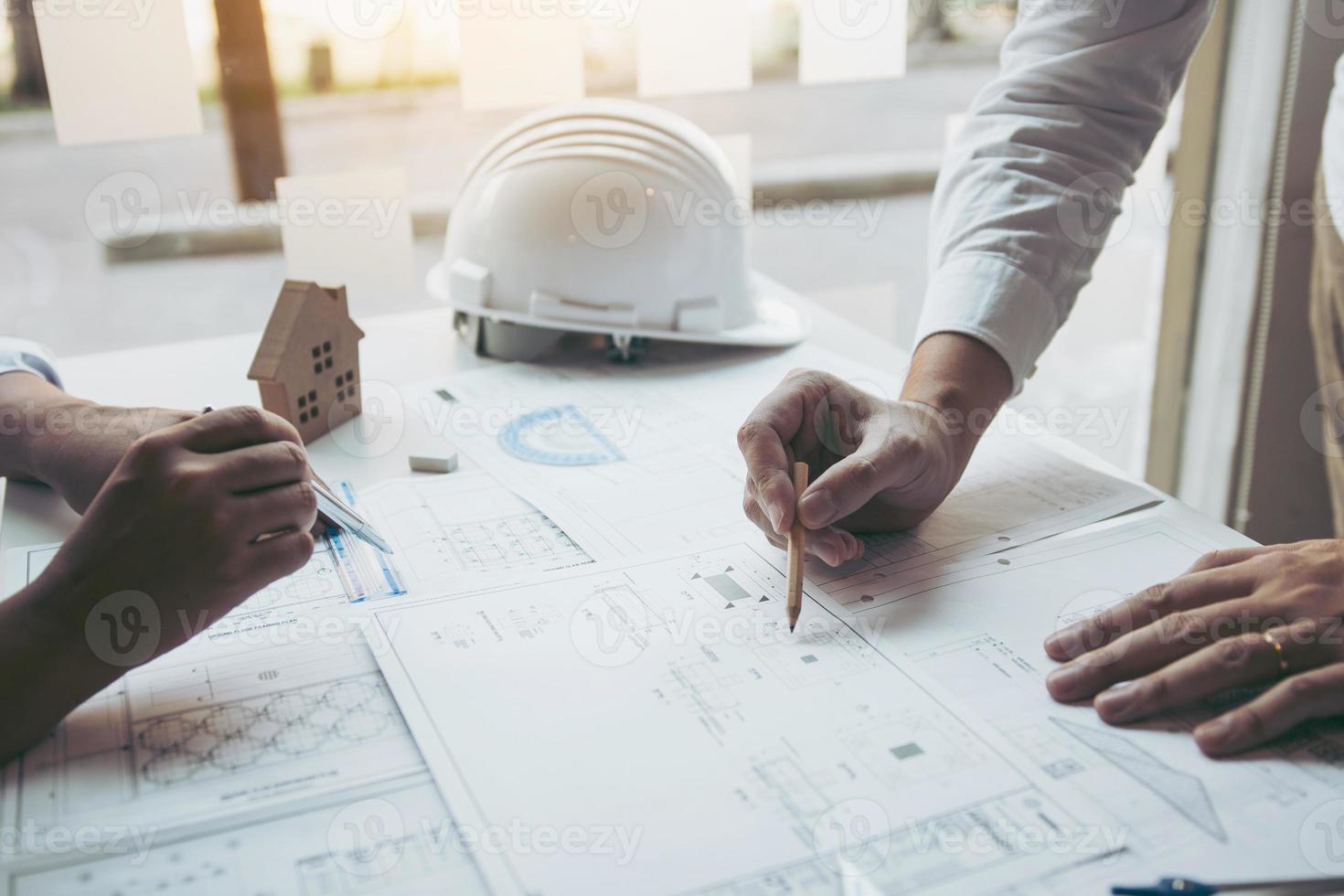 Engineering man showing blueprint detail for people buying house. photo