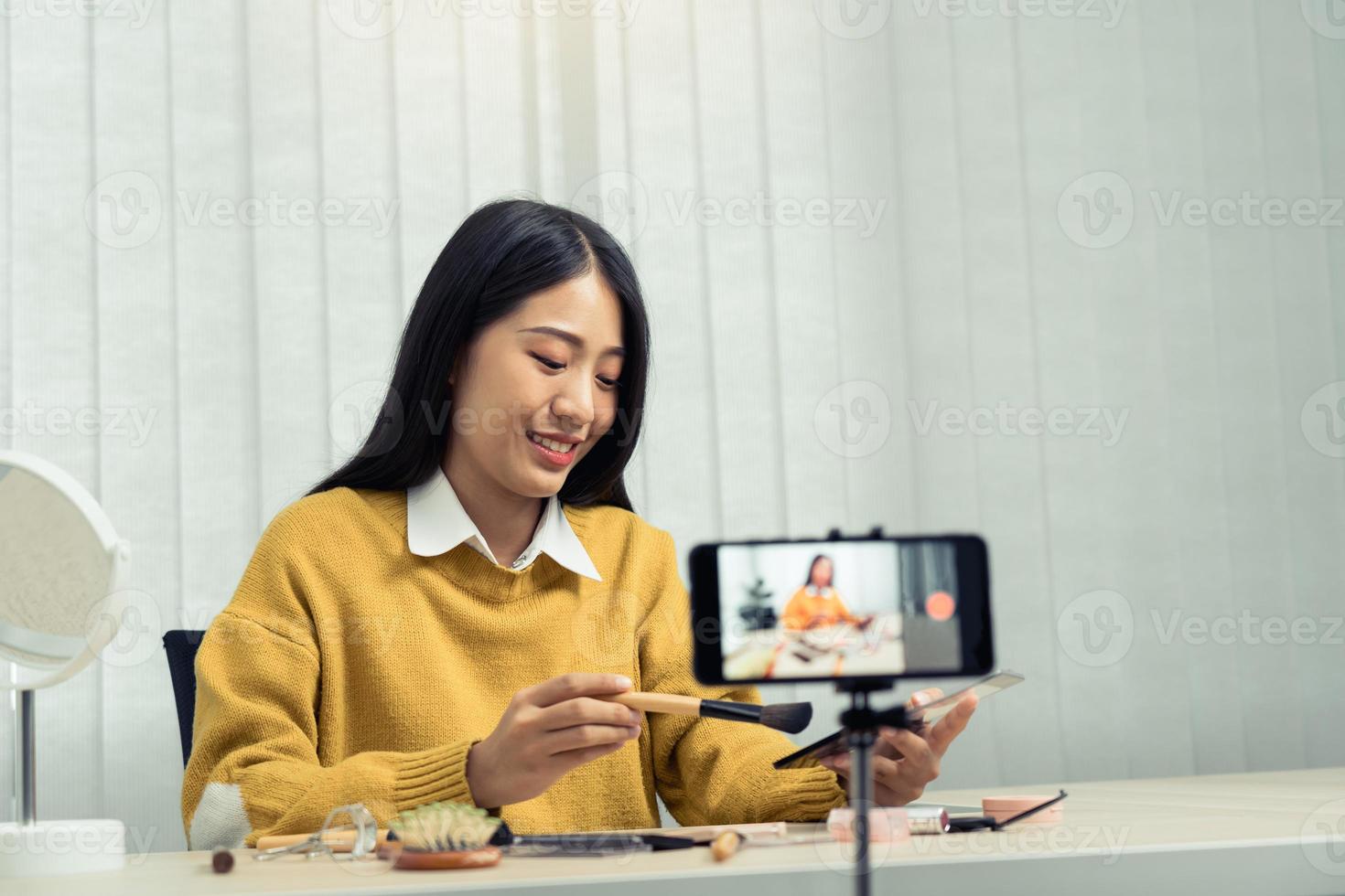 la joven bloguera de belleza asiática está exhibiendo productos cosméticos, así como tutoriales sobre cómo aplicar y grabar tutoriales de maquillaje en las redes sociales. foto