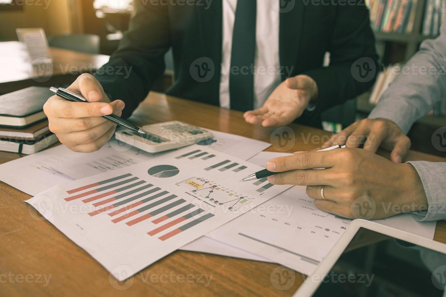 dos hombres de negocios están trabajando analizando el presupuesto anual de la empresa y usando una tableta digital para encontrar resultados de datos de información. foto