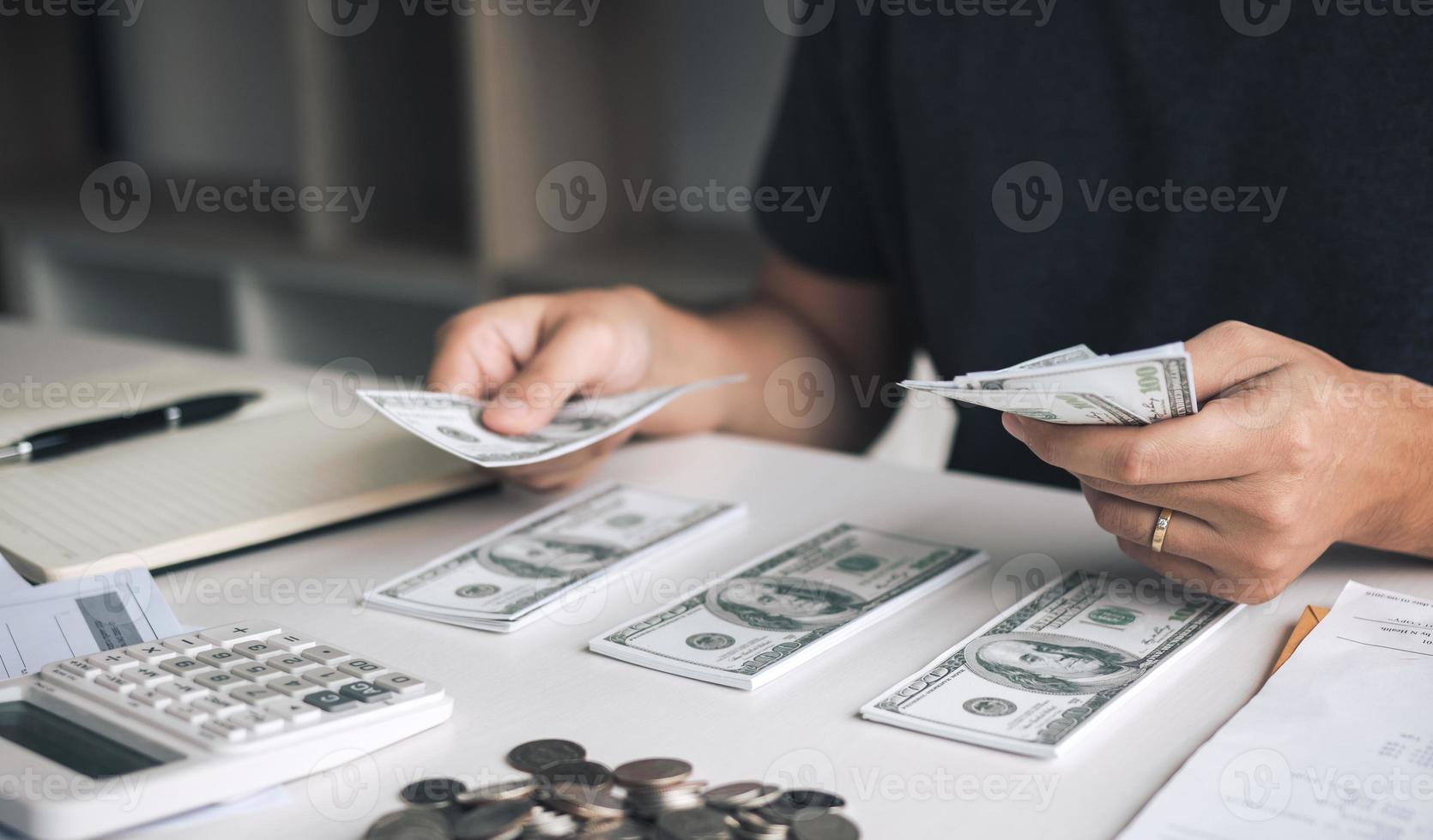 los hombres asiáticos tienen billetes en efectivo y los colocan sobre la mesa con la idea de ahorrar dinero. foto