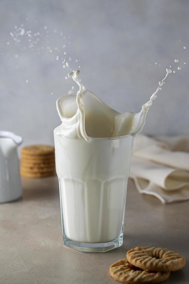 salpicaduras de leche fresca. verter leche en un vaso creando salpicaduras sobre un fondo blanco. enfoque selectivo. foto