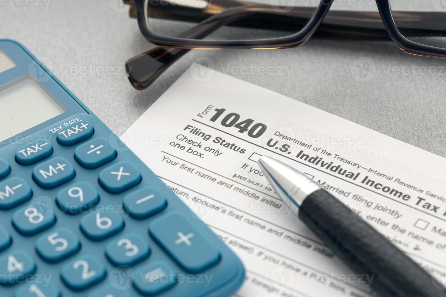 Tax concept. Tax form, calculator, eyeglasses and pen on table photo