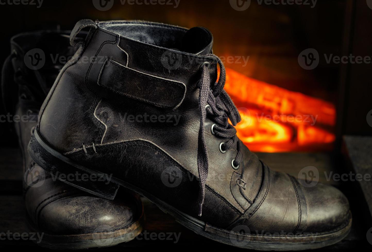 Casual gray leather shoes for men on wooden board with fireplace in the background. Dark mood style. Horizontal image. photo