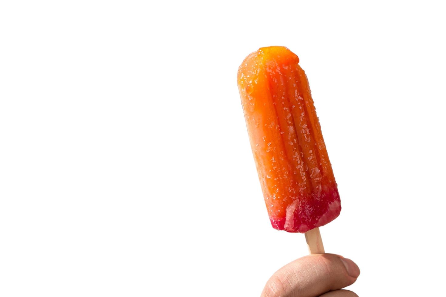 juicy popsicles on a stick in a hand on a white background photo