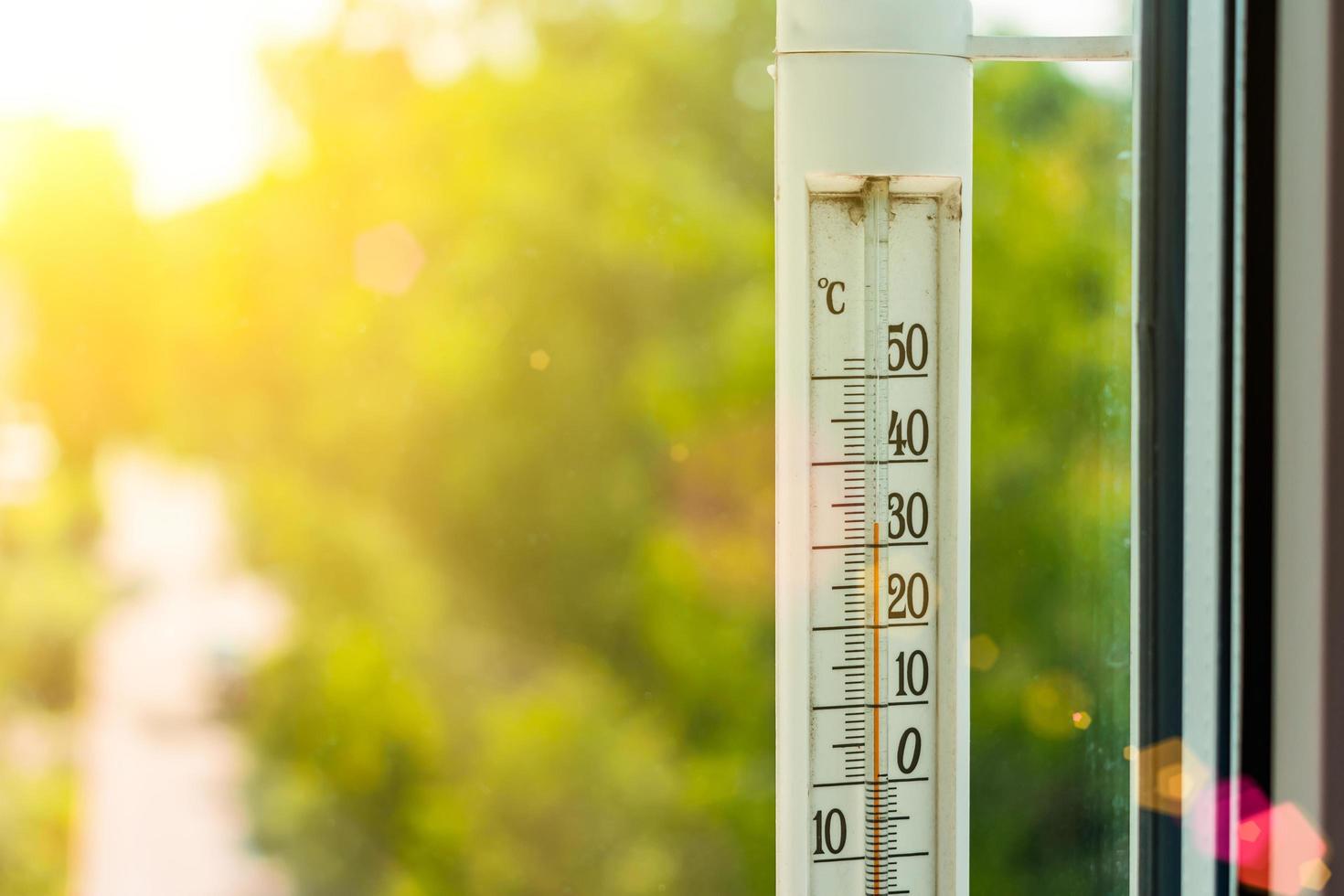 The thermometer outside the window shows a very hot air temperature, heated by the rays photo