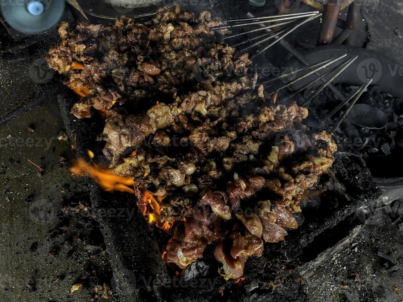 Goat satay on red fire grilling by people. traditional Indonesian food made from mutton. photo