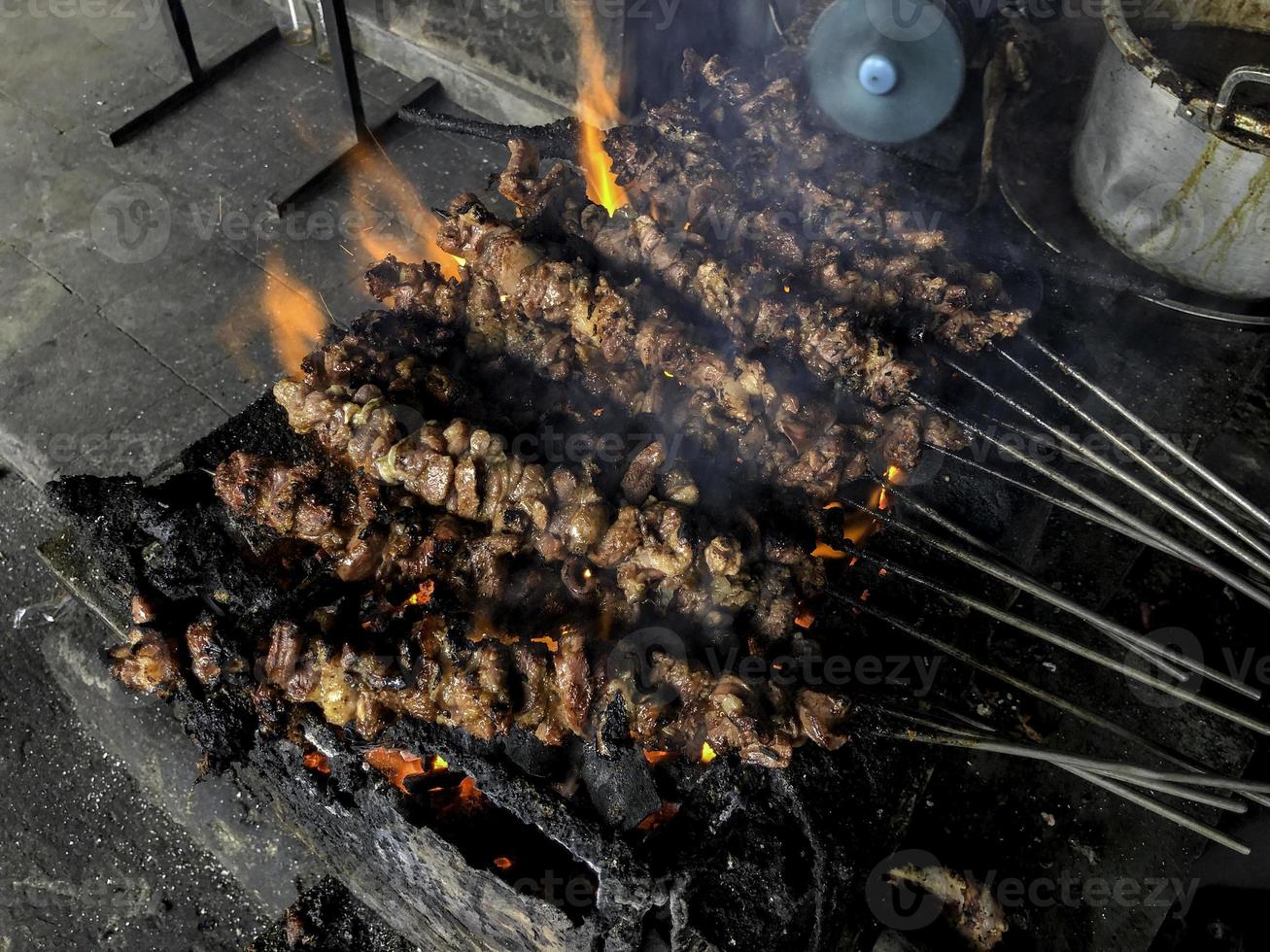 Goat satay on red fire grilling by people. traditional Indonesian food made from mutton. photo