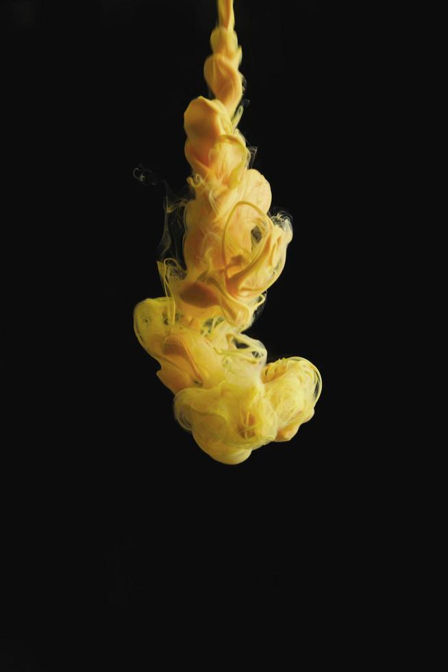 Yellow ink drop in clear water and black background. abstract image for background or color reference. photo