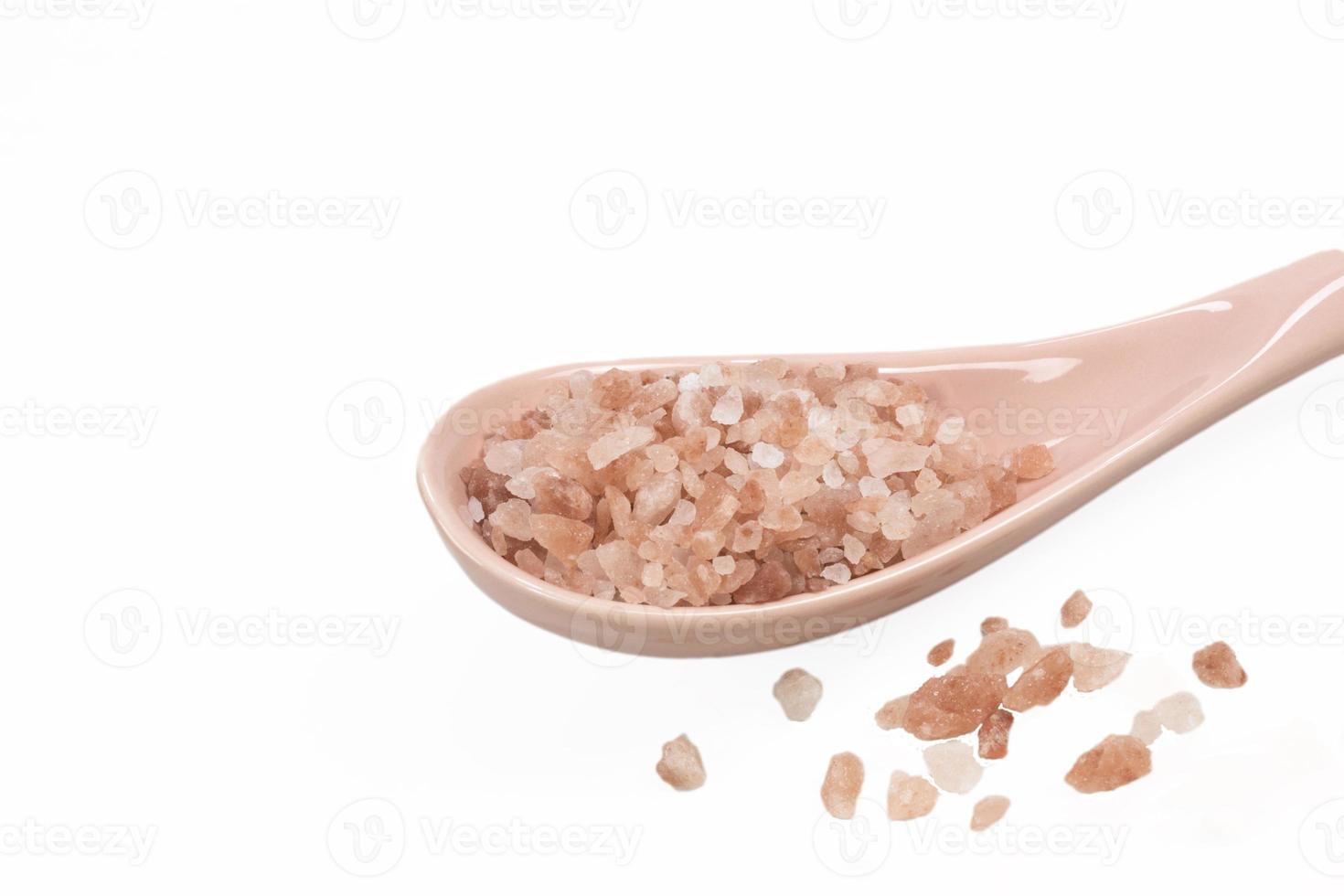 Pink Himalayan salt in spoon on white background. photo