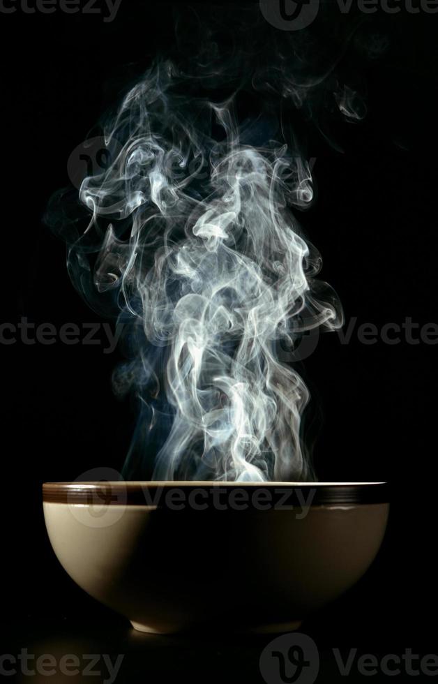 Picture of smoke rising from the food above the cup The concept of hot food. photo