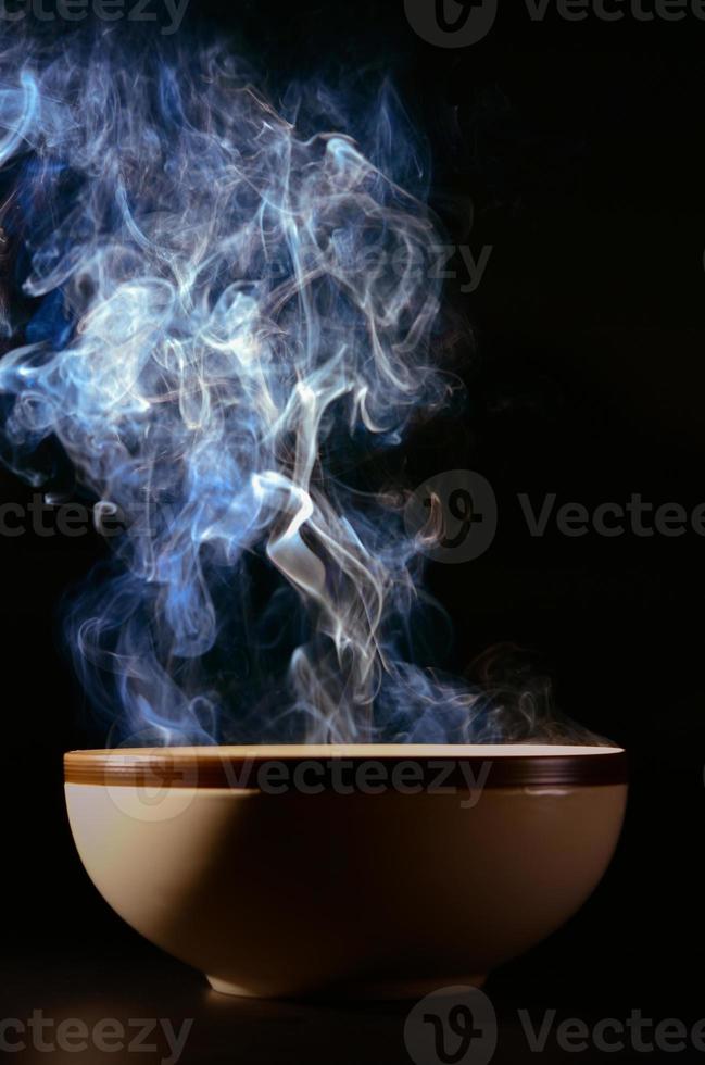 imagen de humo saliendo de la comida por encima de la taza el concepto de comida caliente. foto