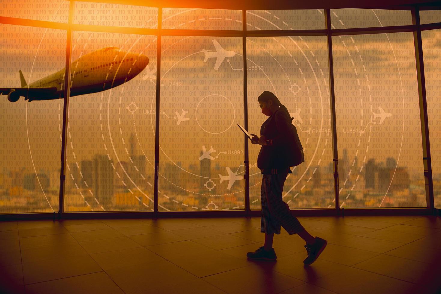 A young tourist walks past a simulated screen showing various flights. for transport and passengers photo