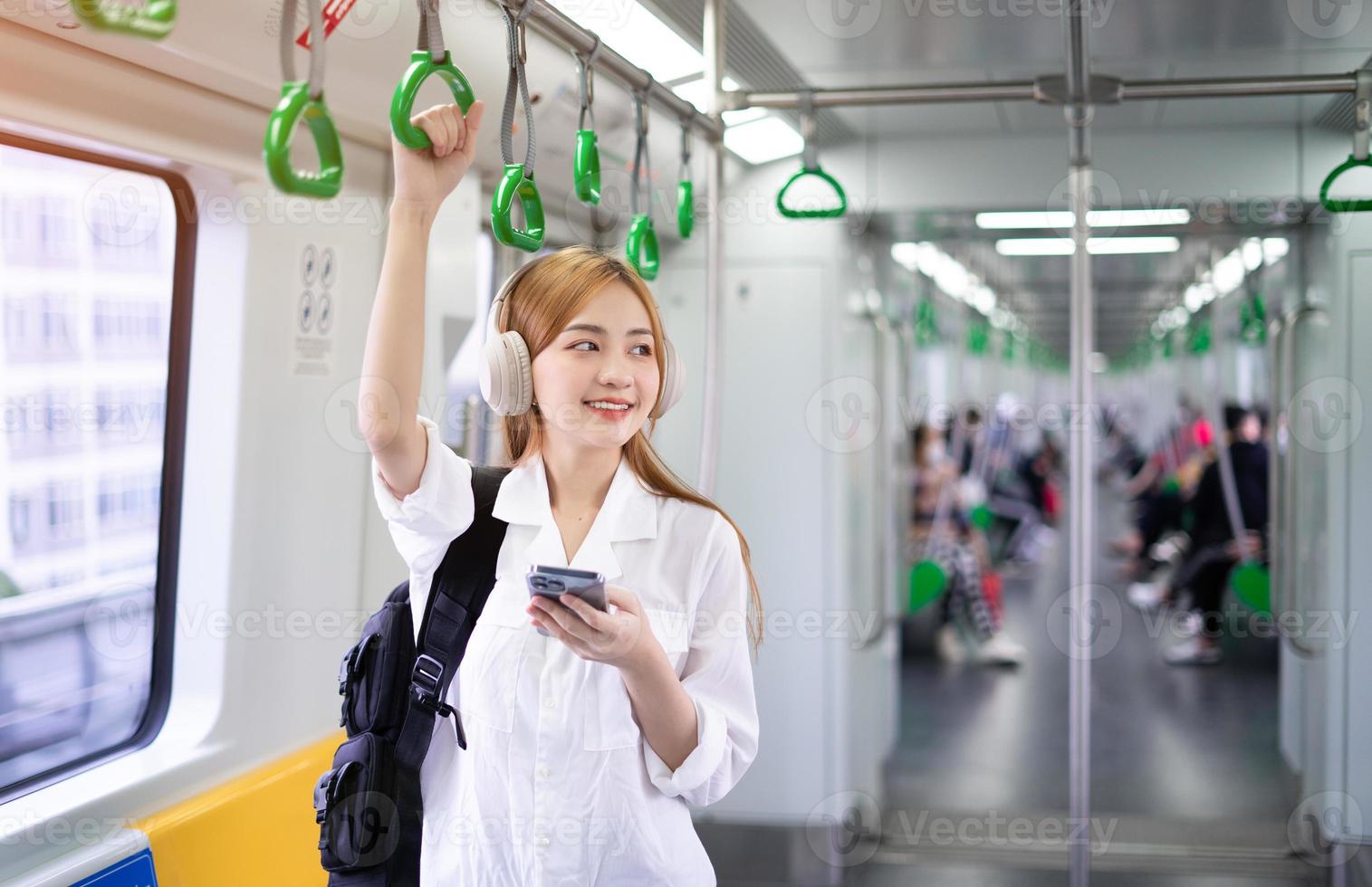 imagen de una joven asiática usando un smartphone en el metro foto