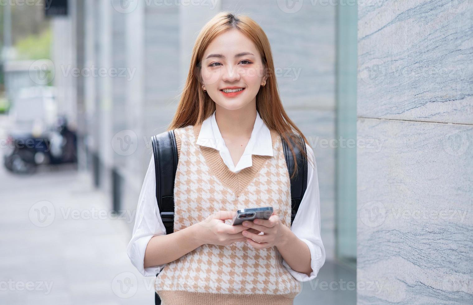 joven asiática usando un teléfono inteligente en la calle foto