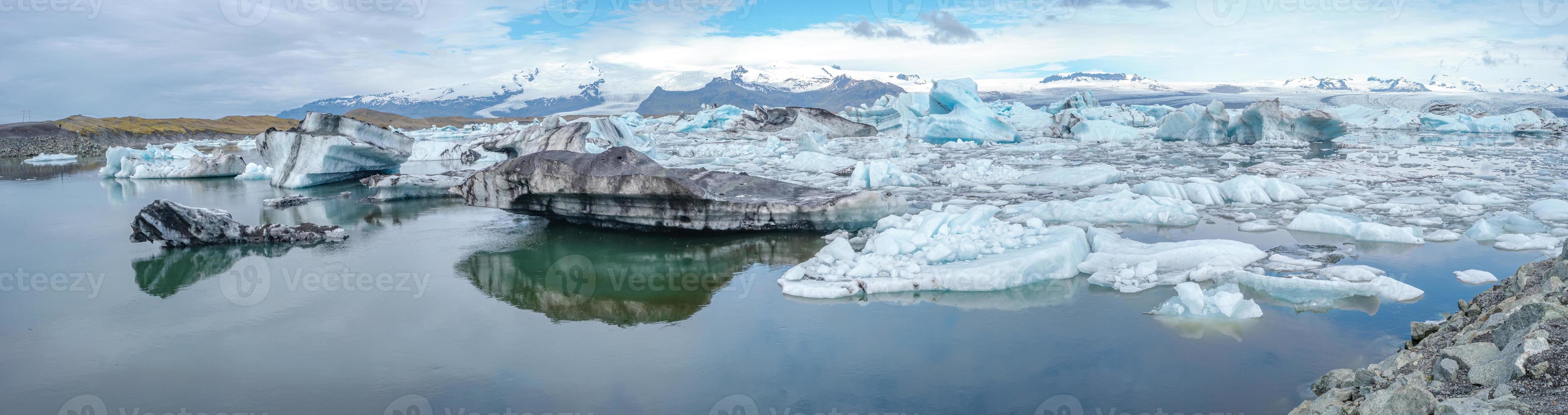 Panoramic view of Glacier Lagoon Jokulsarlon with icebergs and Vatnajokull Glacier tongue, Iceland, summer, with a touristic tour boat and people. photo