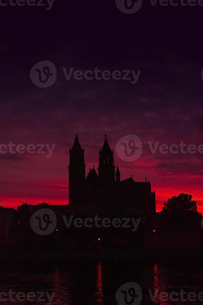 Cover page with silhouettes of a medieval castle, cathedral at beautiful bloody sunset at historical downtown of Magdeburg, old town, Elbe river with copy space for text, Germany. photo