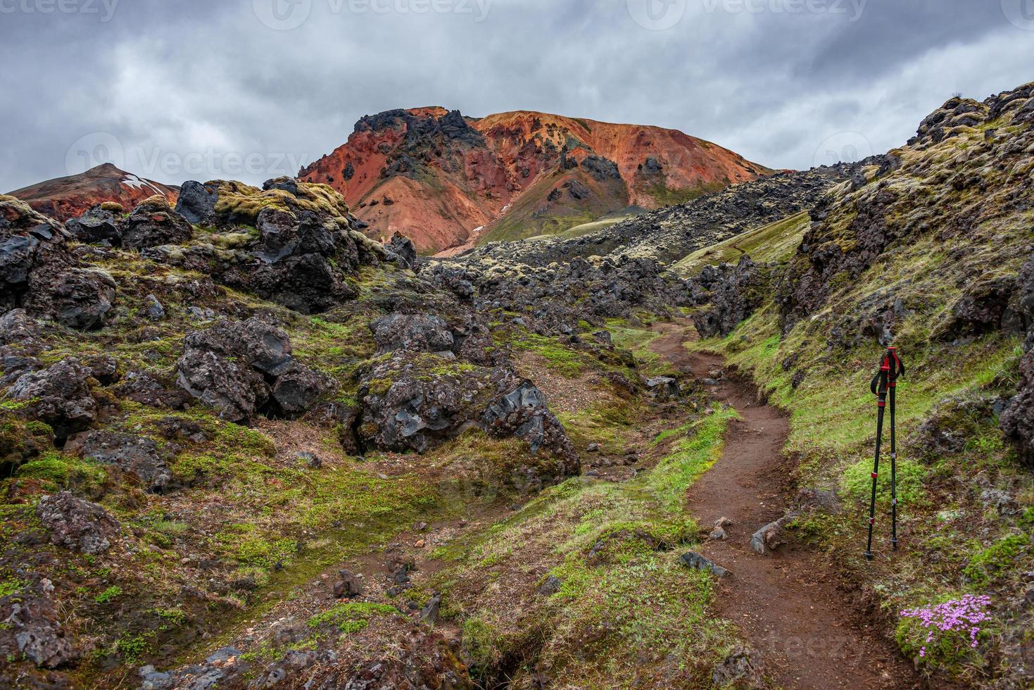 hermoso paisaje islandés de coloridas montañas volcánicas de arco iris landmannalaugar, en la famosa ruta de senderismo laugavegur con un cielo espectacular y bastones de senderismo en islandia. foto