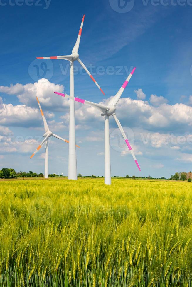 View over beautiful green farm landscape with light and shadow waves in Germany with clouds in sky, and wind turbines to generate electrical power. photo