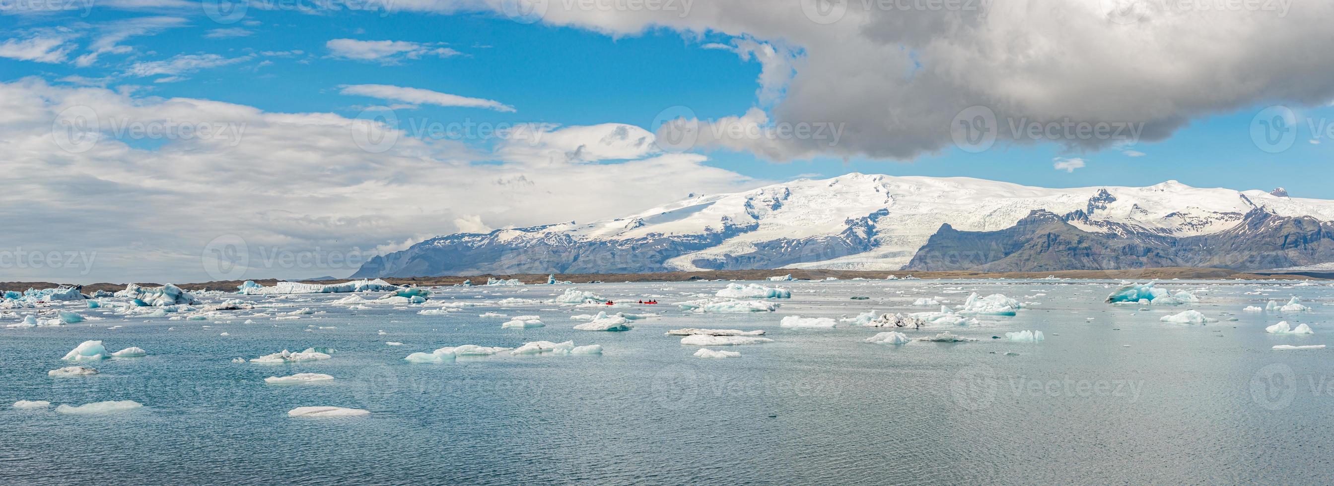 Panoramic view of Glacier Lagoon Jokulsarlon with icebergs and Vatnajokull Glacier tongue, Iceland, summer, with a touristic kayaking and people. photo