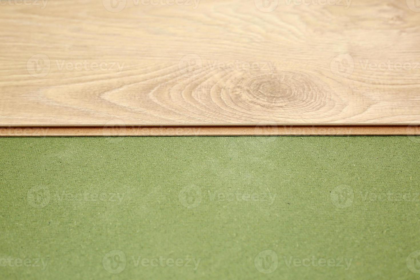 instalar piso de parquet o laminado de madera en la habitación sobre una base verde. montaje de paneles de forma rápida y sencilla: suelos asequibles. poner suelo laminado en casa foto