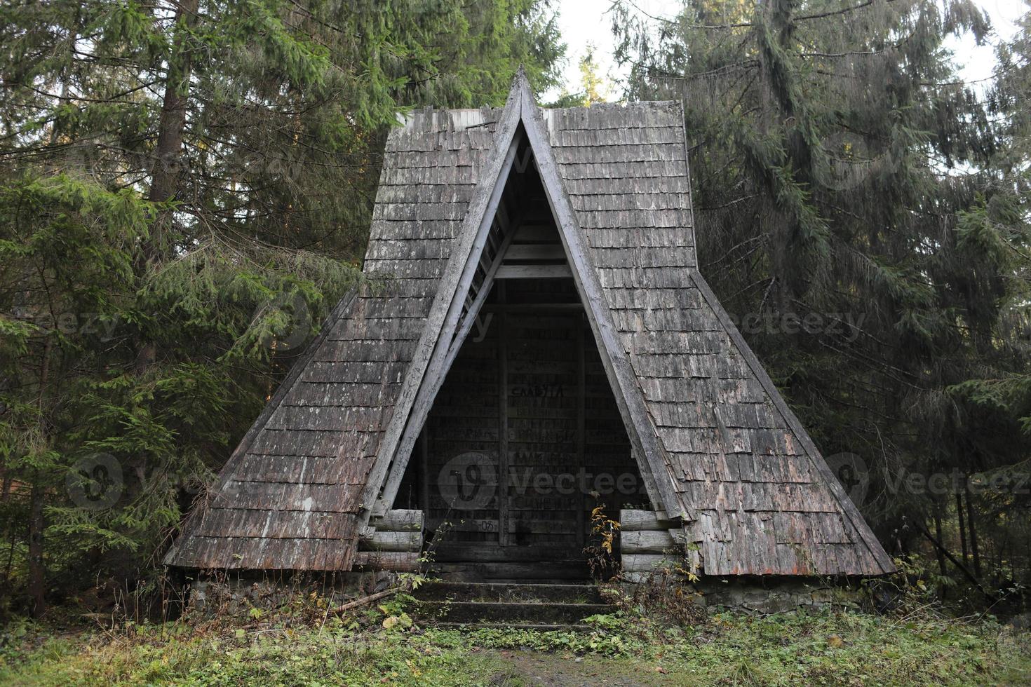 old wooden house in autumn forest lake in Carpathians photo