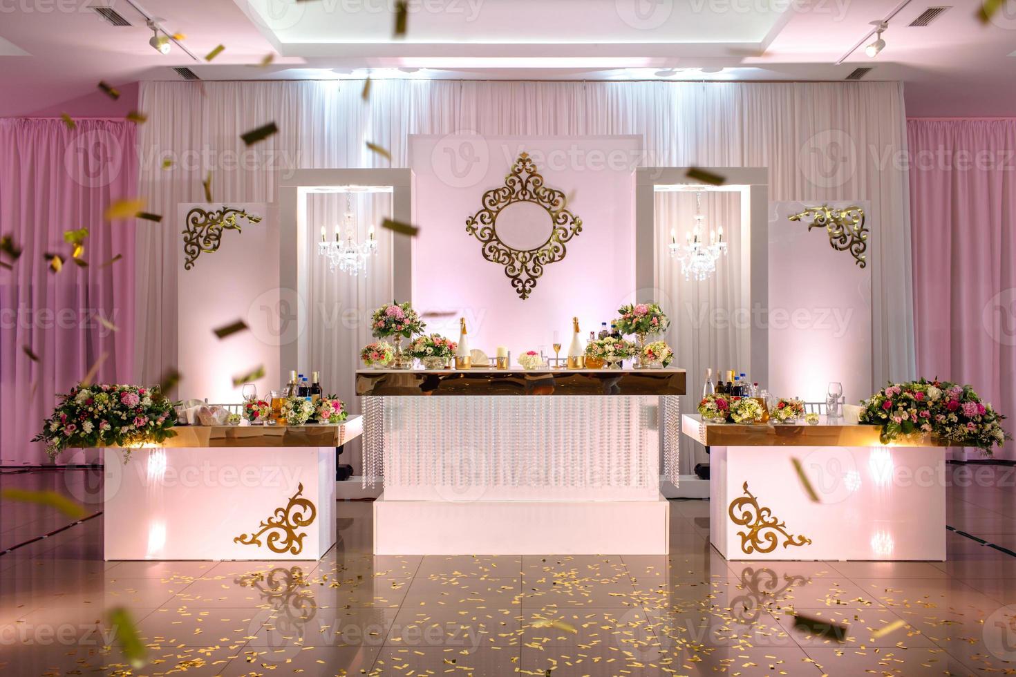 Festive table decorated with composition of white, red and pink flowers and greenery in the banquet hall. photo