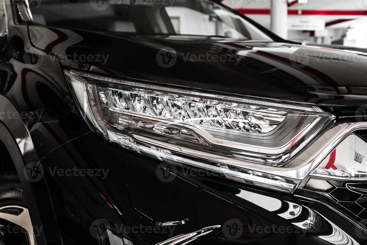 Modern luxury car close-up. Headlight lamp of new cars,copy space. A modern and elegant car illuminated. selective focus photo