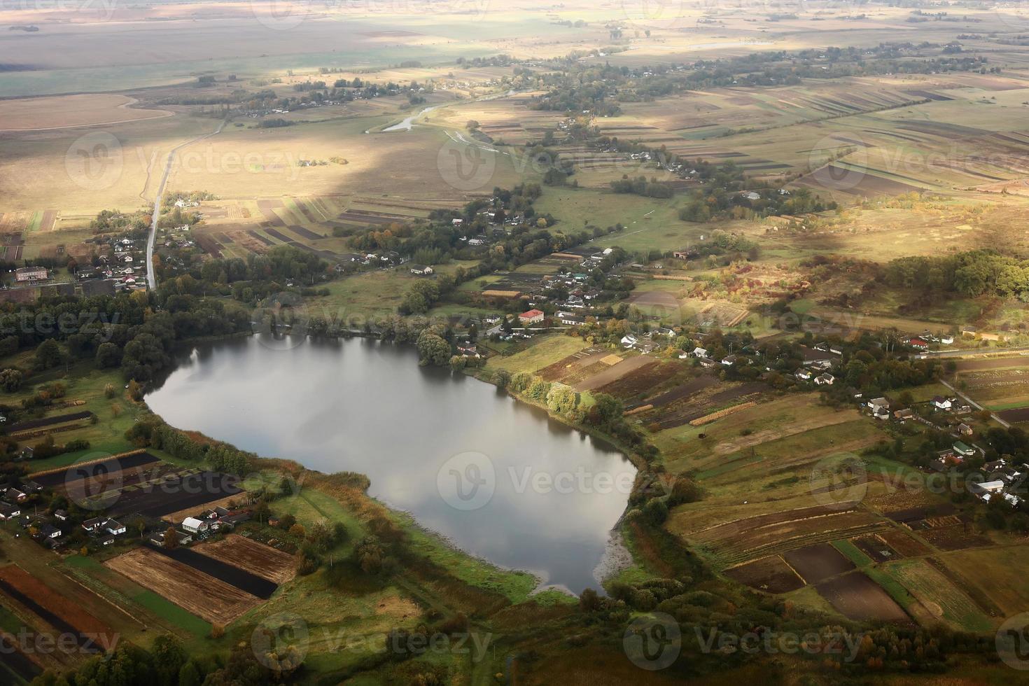Aerial view of farmland area landscape and lake from airplane. Landscape with lake. Environment protection. Drone flight. view of the village from the sky. photo with noise