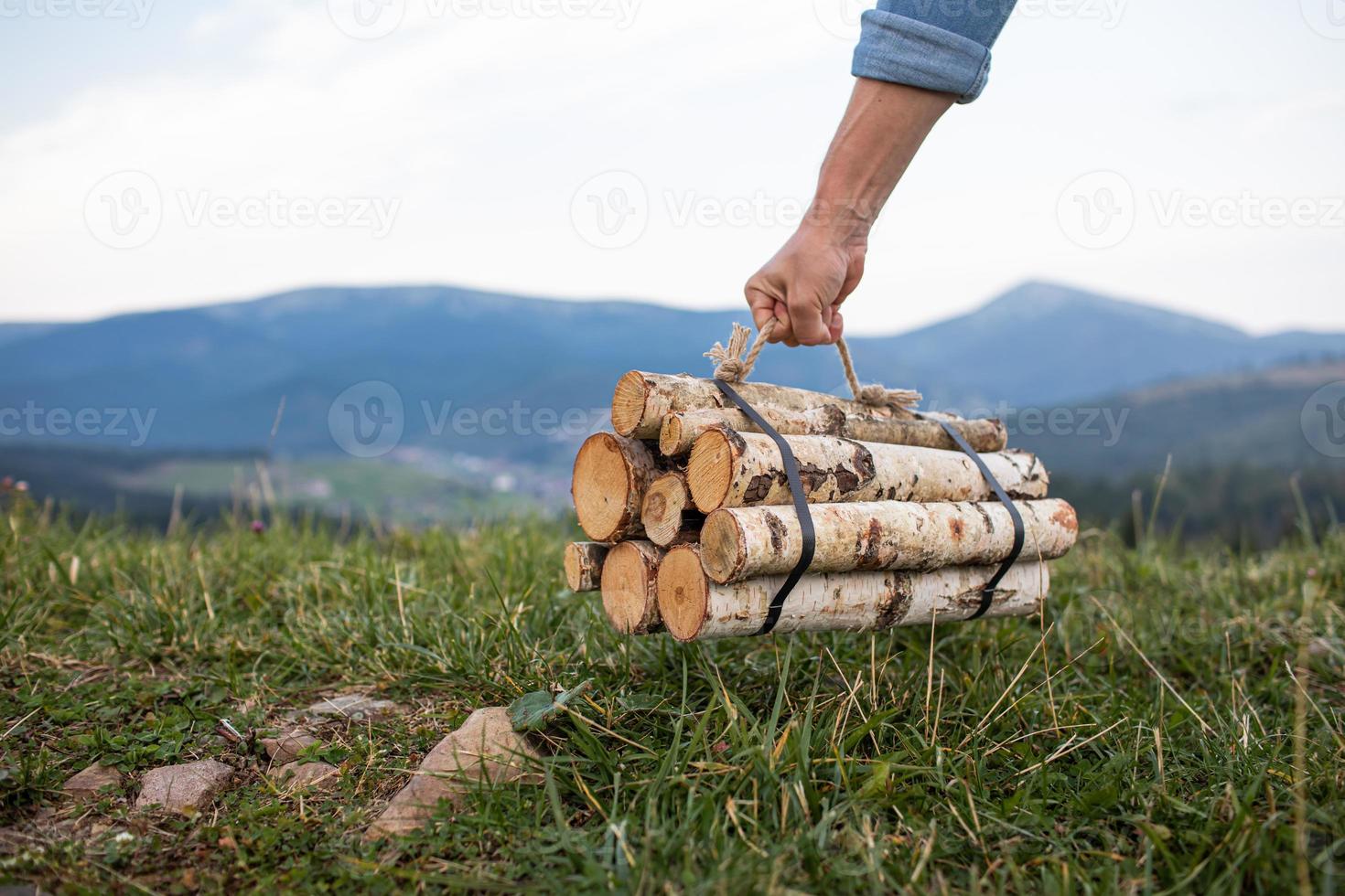 Man traveler hands holding firewood for fire in mountains. place for inscription. photo