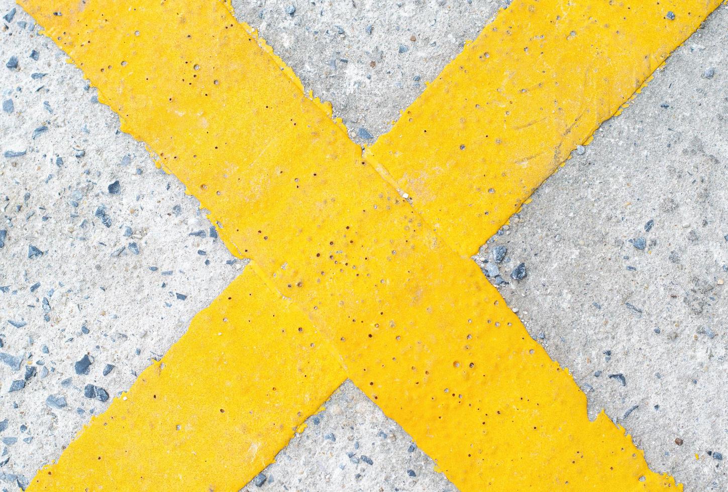 yellow cross symbol on the road photo