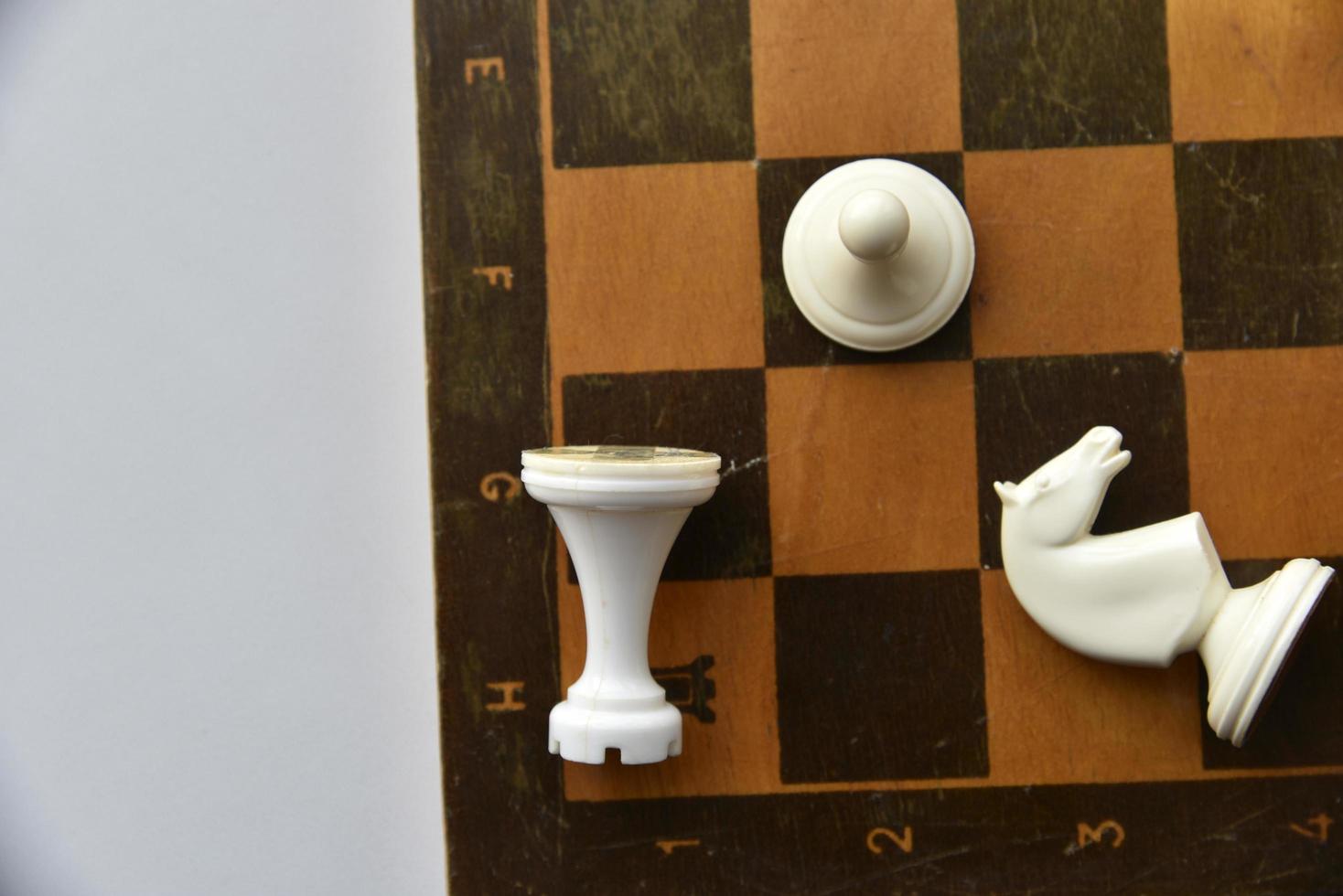 An old chessboard with white and black pieces photo
