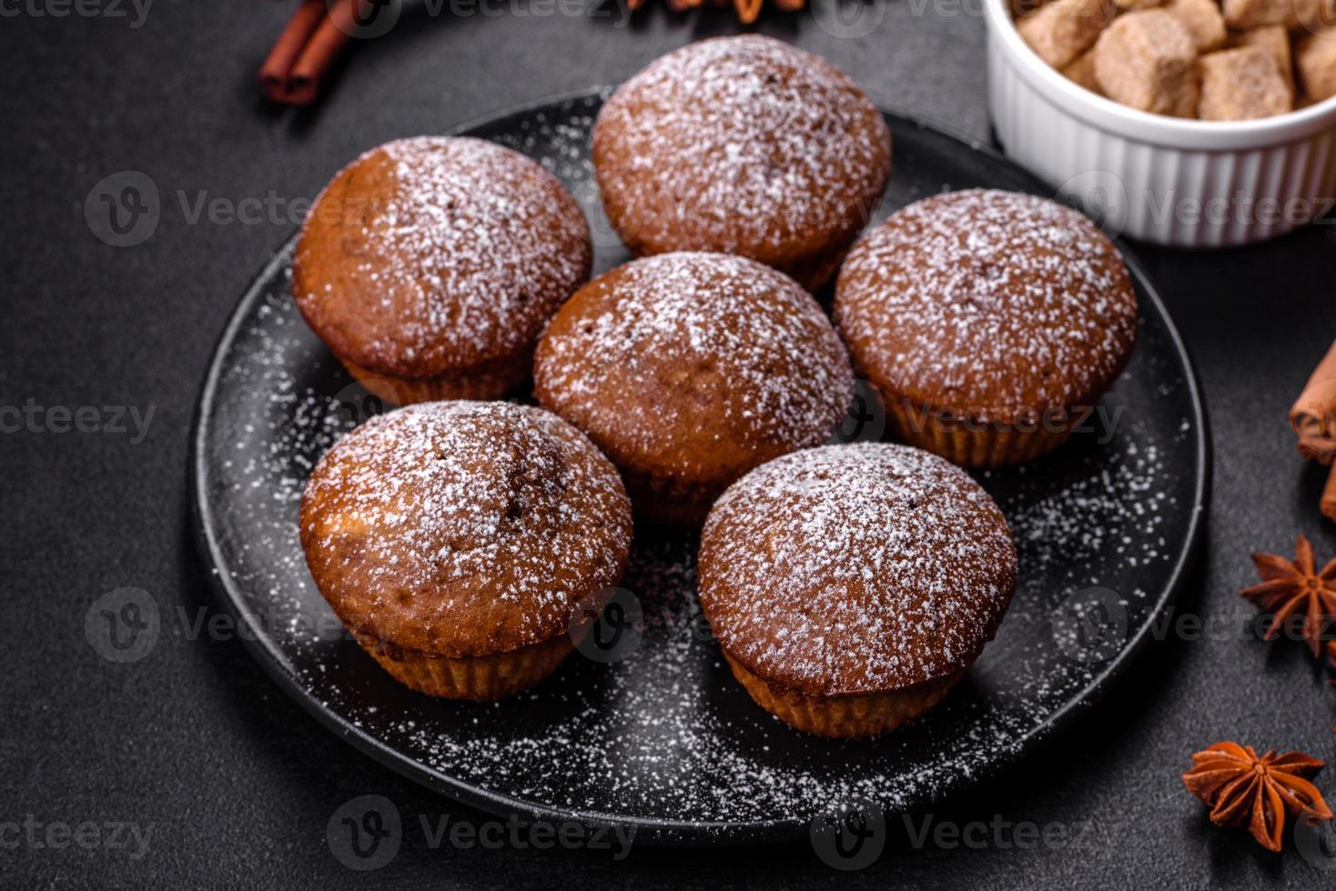 Beautiful delicious cupcakes with cocoa and raisins on a black concrete background photo