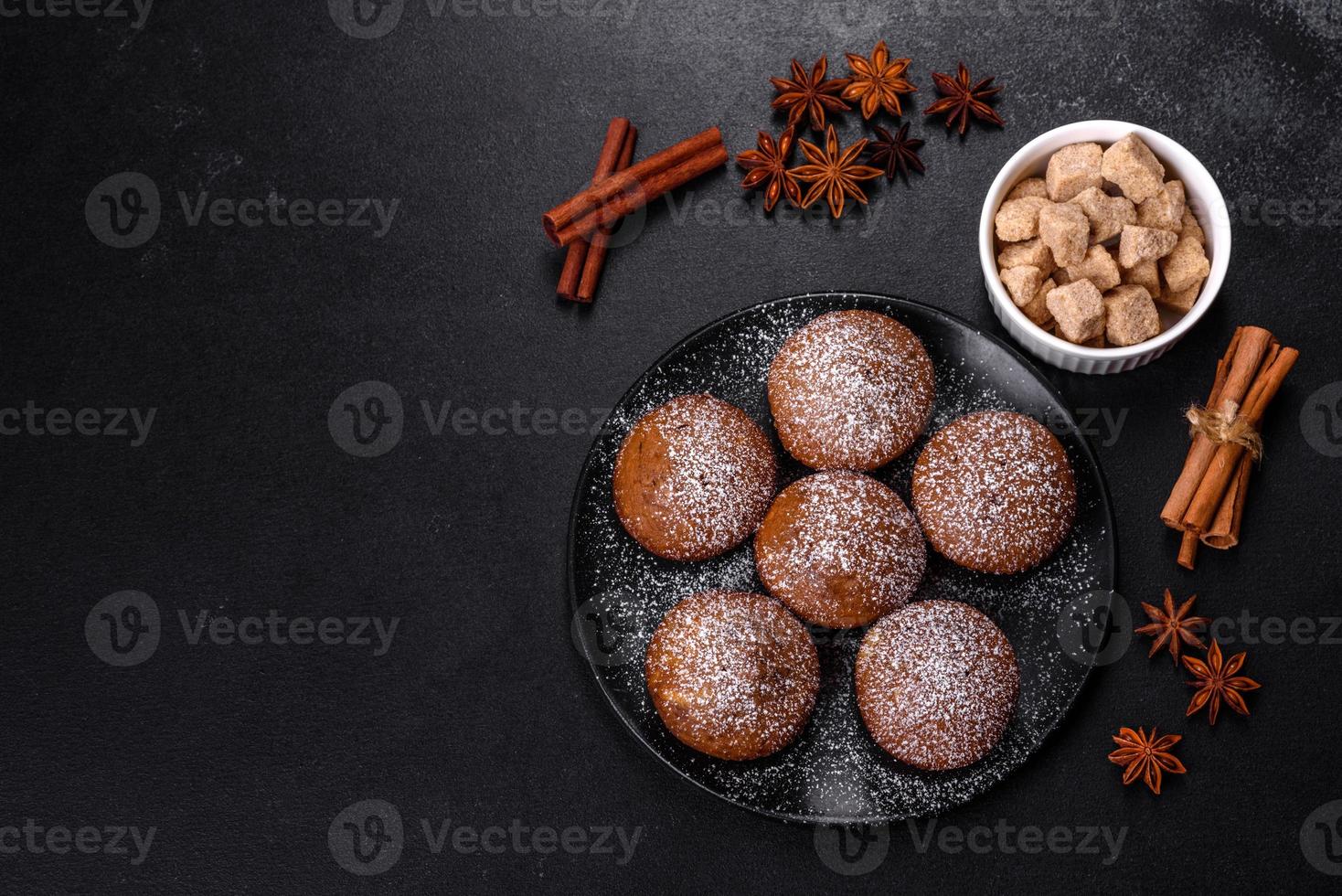 Beautiful delicious cupcakes with cocoa and raisins on a black concrete background photo