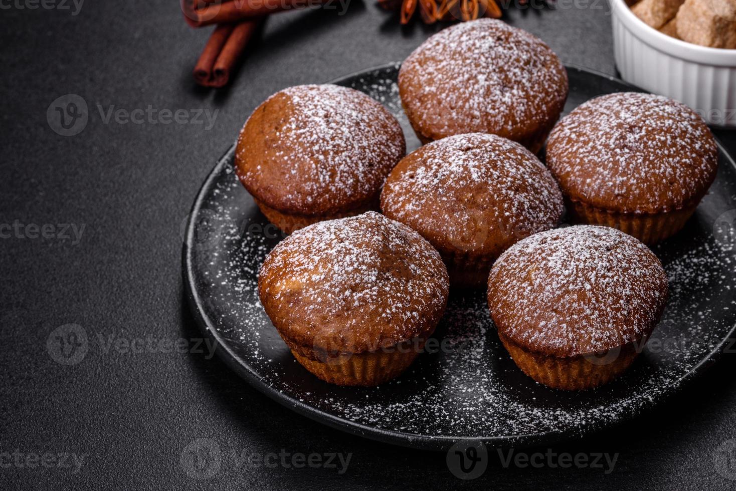 Beautiful delicious cupcakes with cocoa and raisins on a black concrete background photo