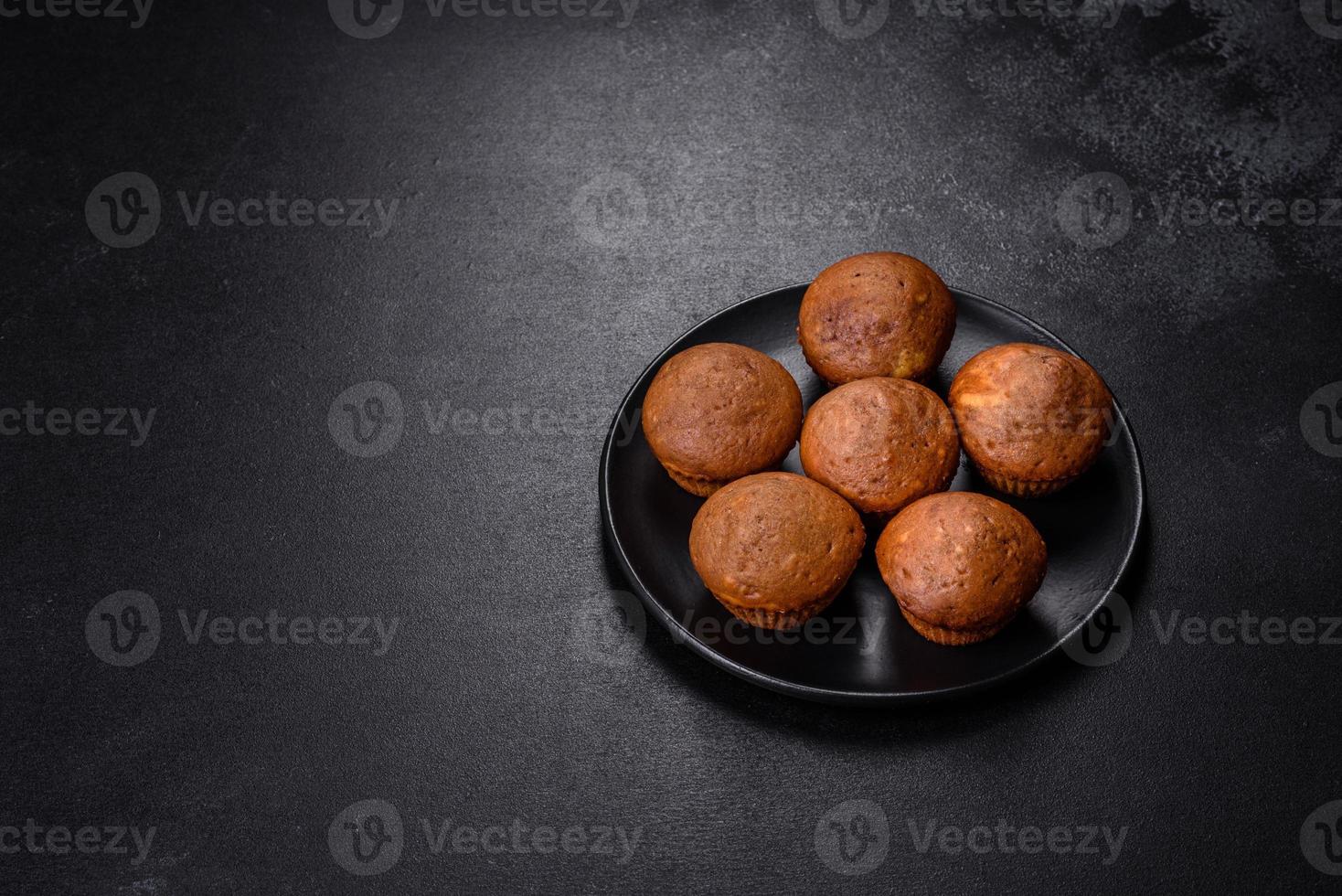 Beautiful delicious cupcakes with cocoa and raisins on a black concrete background photo