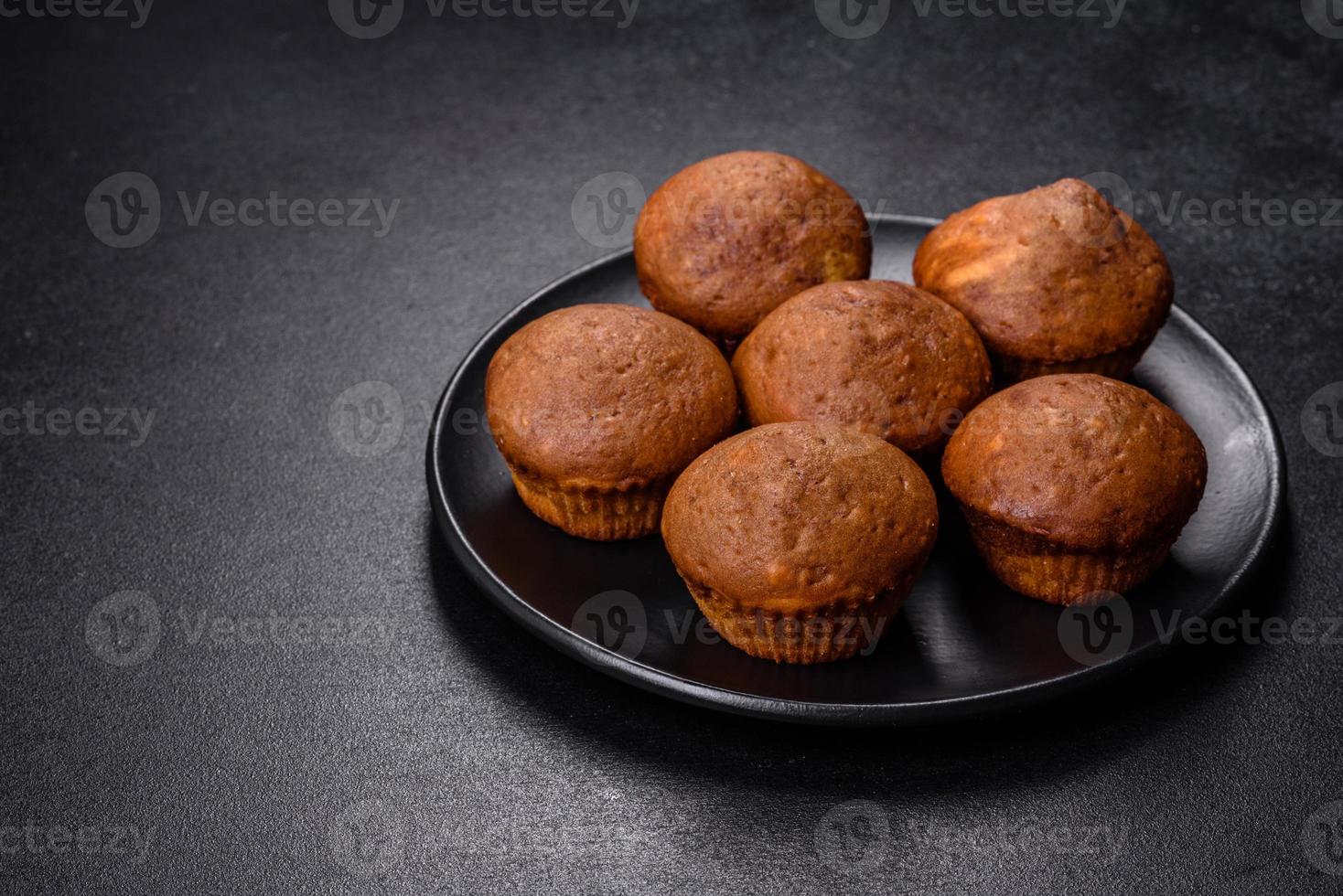 Beautiful delicious cupcakes with cocoa and raisins on a black concrete background photo