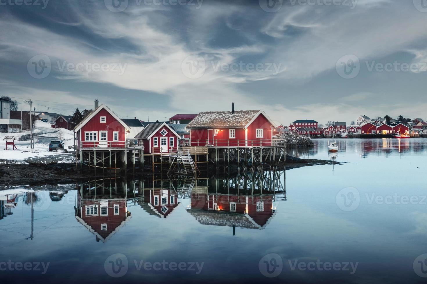 casa tradicional de madera roja en el paseo marítimo en el pueblo de pescadores en invierno en la ciudad de reine, islas lofoten foto