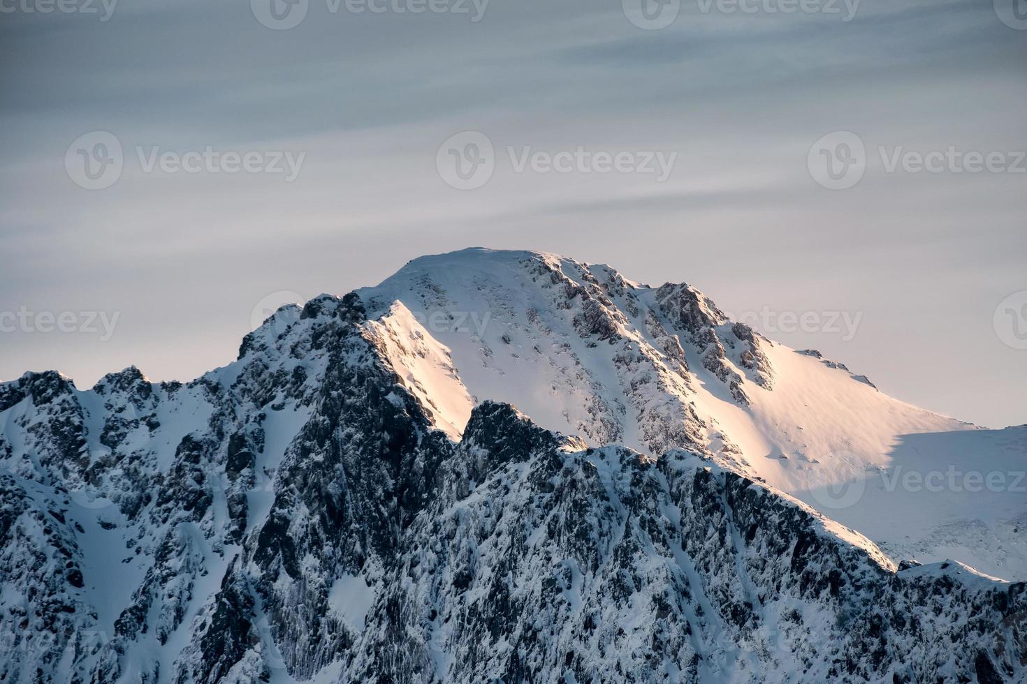 Summit of snow mountain with sunrise shining photo